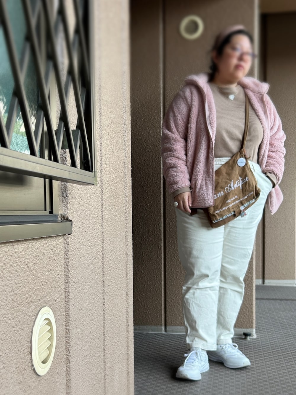 ピンク系のその他アウター、グリーン系のショルダーバッグ、ホワイト系のパンツを着用したレディースの冬コーディネートの2枚目の写真