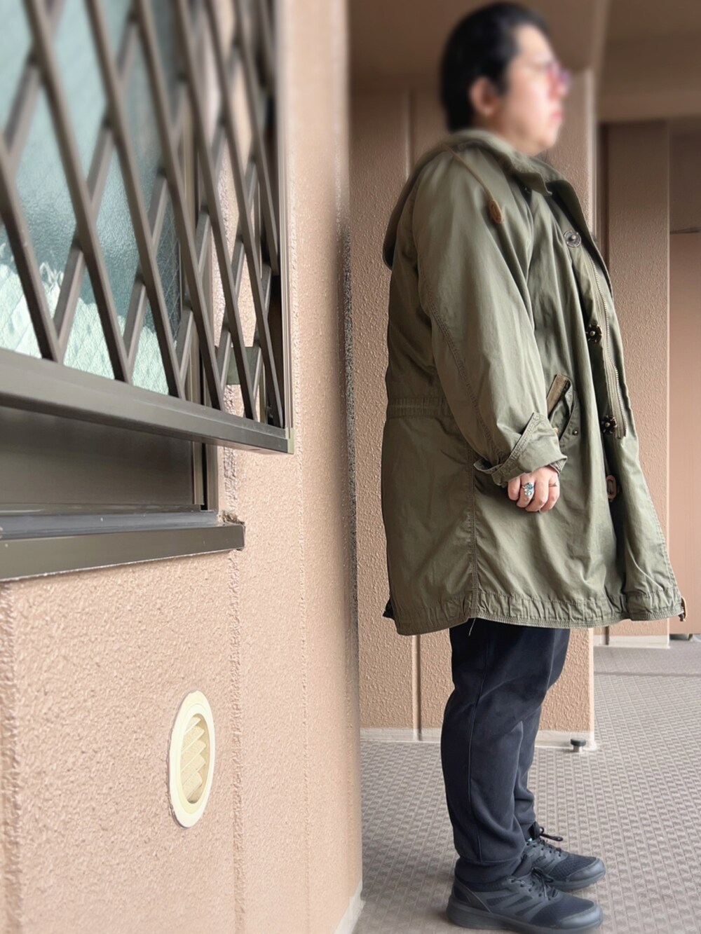 グレー系のスウェット、グリーン系のモッズコート、ブラック系のその他パンツを着用したレディースの冬コーディネートの2枚目の写真