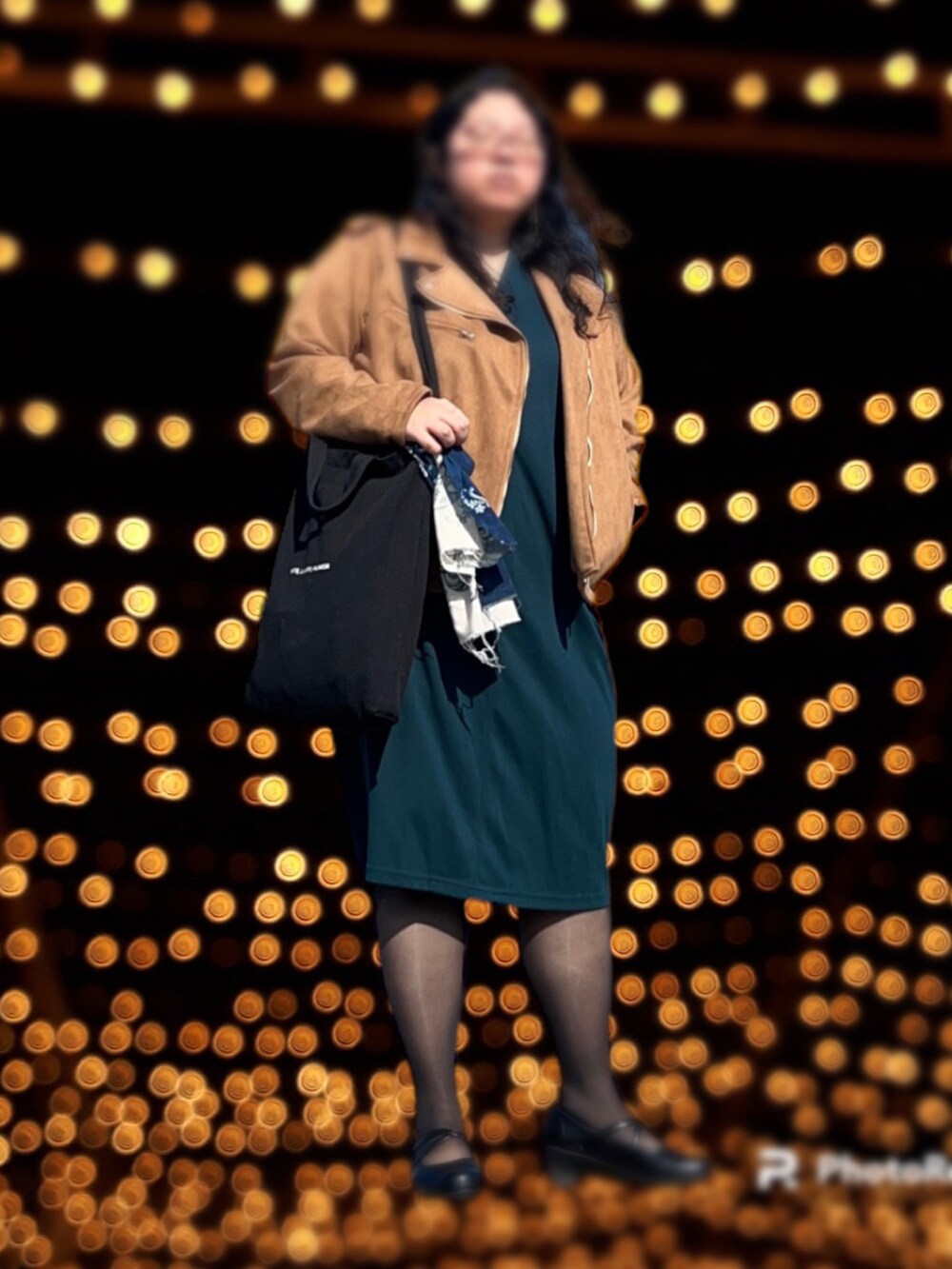 グリーン系のワンピース、ブラウン系のライダースジャケット、ブラック系のトートバッグを着用したレディースの冬コーディネートの2枚目の写真