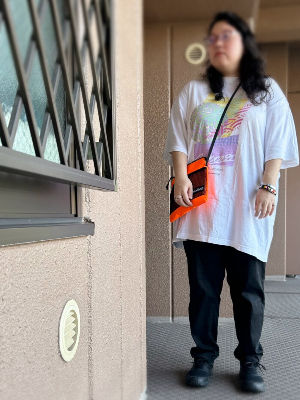 ホワイト系のTシャツ/カットソー、オレンジ系のショルダーバッグ、ブラック系のその他パンツを着用したレディースの夏コーディネートの2枚目の写真