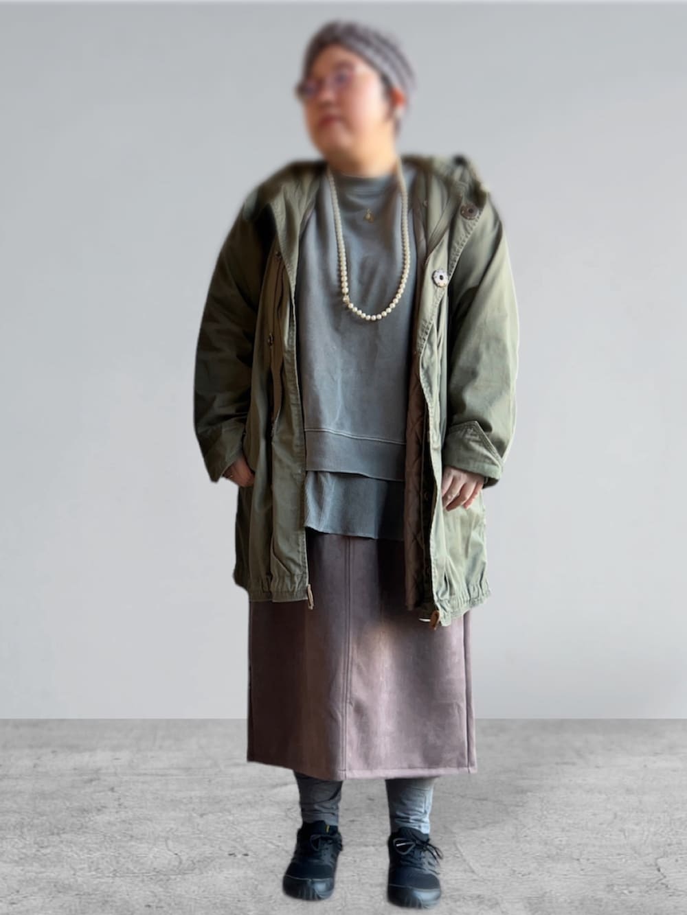 グレー系のスウェット、グリーン系のモッズコート、ブラウン系のスカートを着用したレディースの冬コーディネートの3枚目の写真