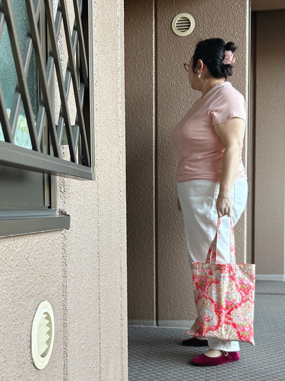レッド系のトートバッグ、レッド系のバレエシューズ、ピンク系のTシャツ/カットソーを着用したレディースの秋コーディネートの3枚目の写真