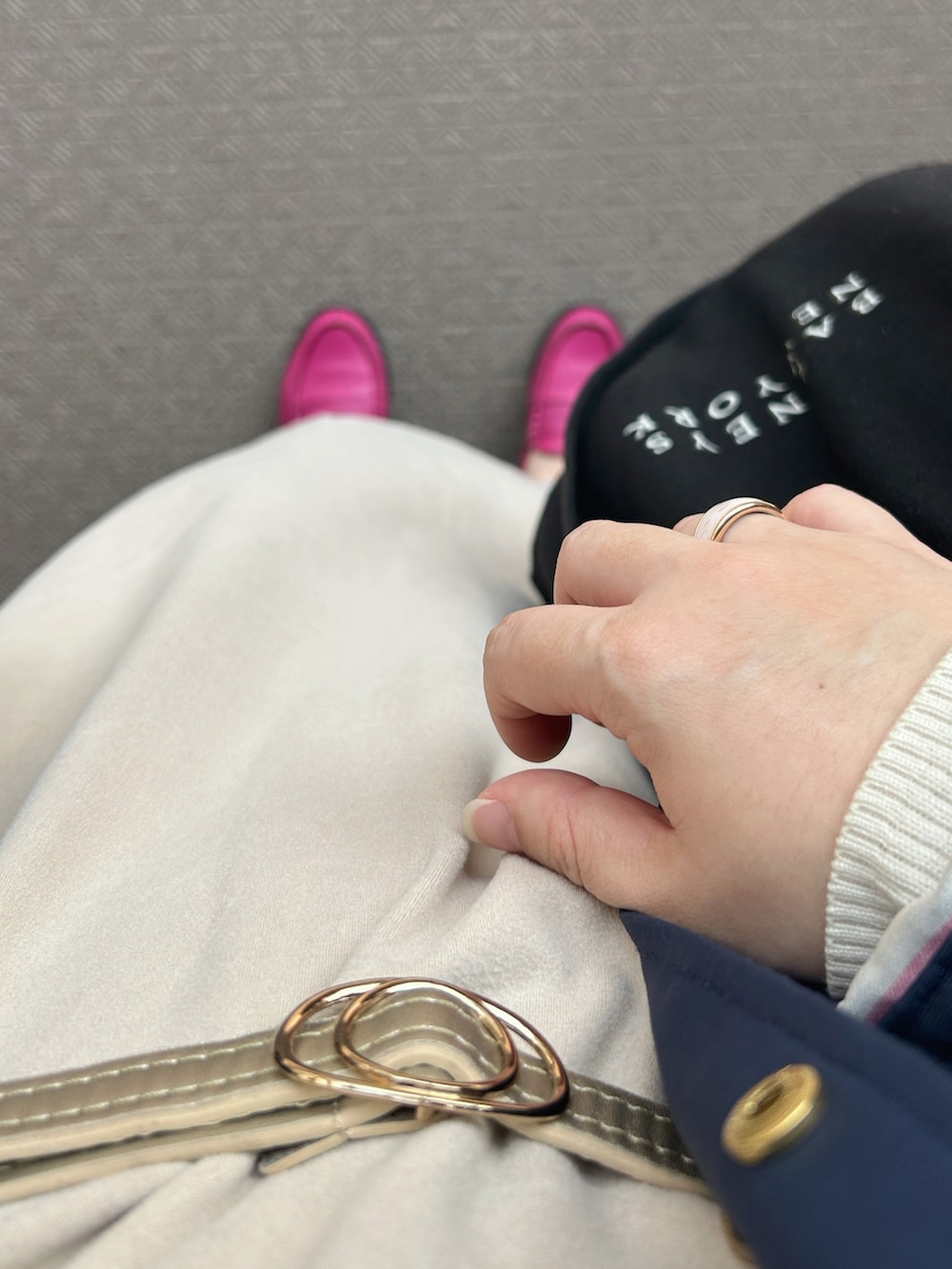 ベージュ系のジャンパースカート、ホワイト系のニット/セーター、ブルー系のマウンテンパーカーを着用したレディースの夏コーディネートの4枚目の写真