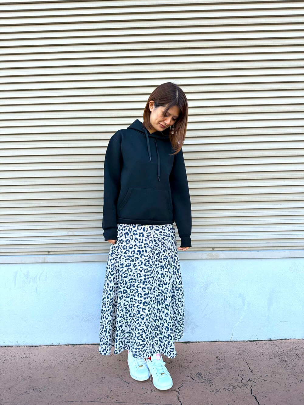 ホワイト系のスカート、ホワイト系のスニーカーを着用したレディースの秋コーディネートの2枚目の写真