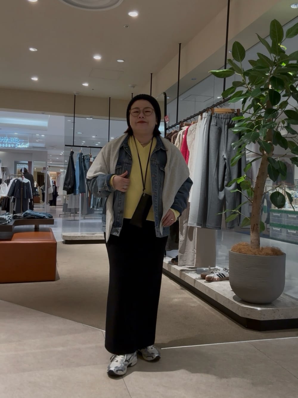 ブルー系のデニムジャケット、イエロー系のニット/セーター、グレー系のストール/ショールを着用したレディースの冬コーディネートの2枚目の写真