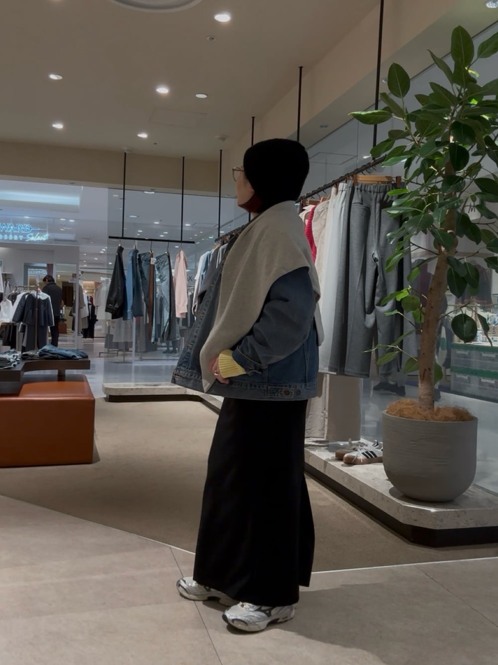 ブルー系のデニムジャケット、イエロー系のニット/セーター、グレー系のストール/ショールを着用したレディースの冬コーディネートの3枚目の写真