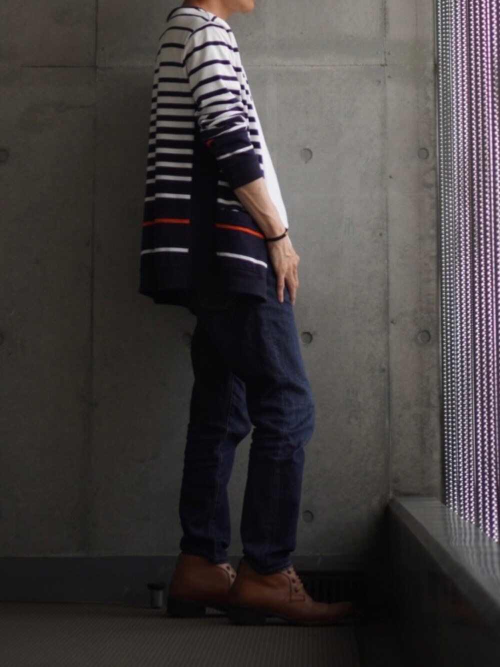 イエロー系のブーツ、ブルー系のデニムパンツ、ホワイト系のTシャツ/カットソーを着用したメンズの夏コーディネートの2枚目の写真