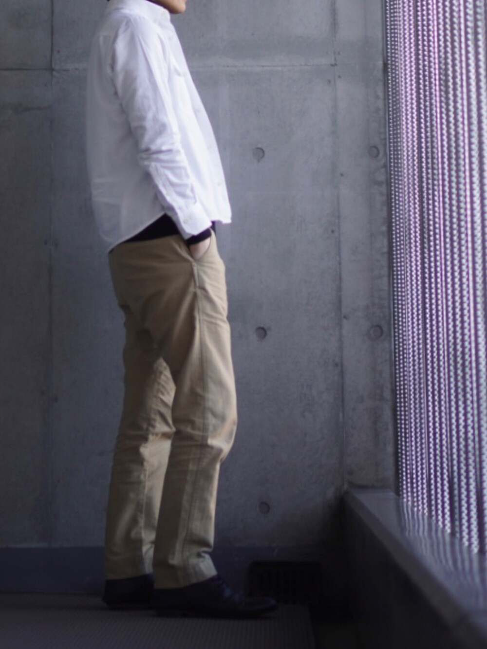 ベージュ系のチノパンツ、ブラック系のローファー、ブラック系のTシャツ/カットソーを着用したメンズの冬コーディネートの2枚目の写真