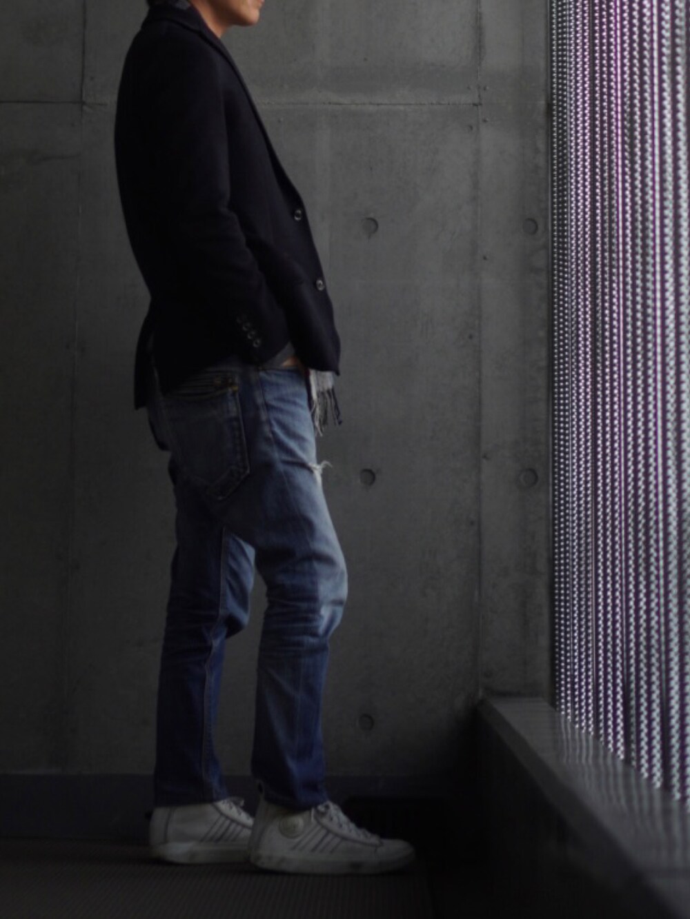 ホワイト系のスニーカー、ブルー系のデニムパンツ、グレー系のニット/セーターを着用したメンズの冬コーディネートの2枚目の写真