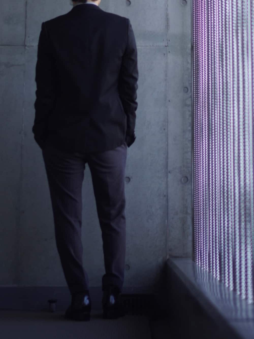 グレー系のスラックス、ブラック系のブーツ、ブルー系のニット/セーターを着用したメンズの冬コーディネートの3枚目の写真