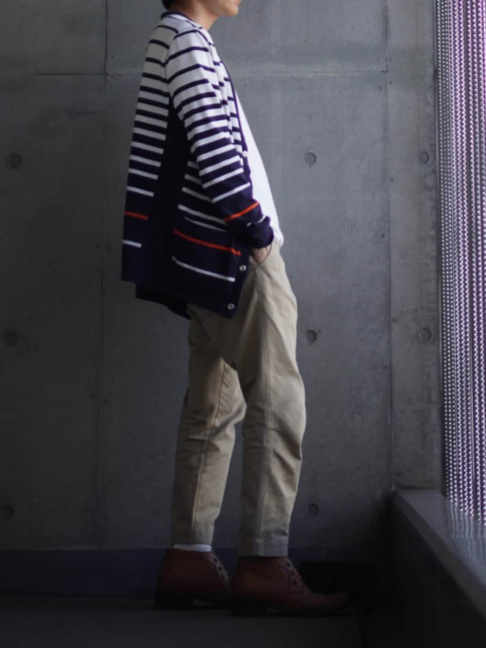 イエロー系のブーツ、ベージュ系のチノパンツ、ホワイト系のTシャツ/カットソーを着用したメンズの春コーディネートの2枚目の写真