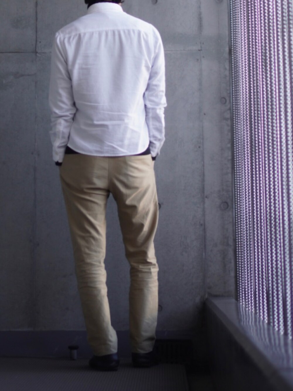 ベージュ系のチノパンツ、ブラック系のローファー、ブラック系のTシャツ/カットソーを着用したメンズの冬コーディネートの3枚目の写真