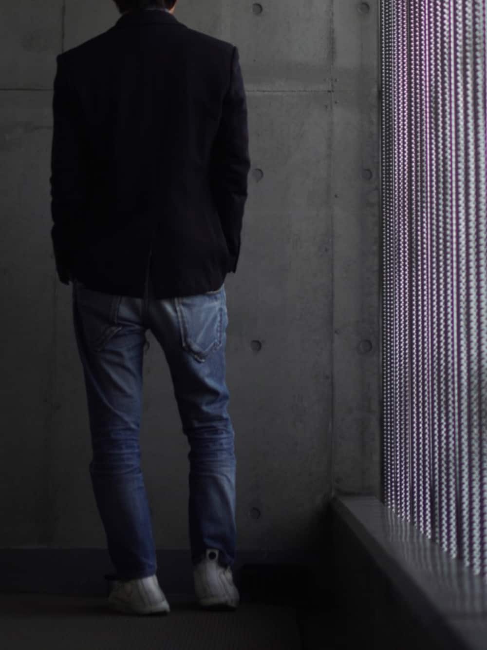 ホワイト系のスニーカー、ブルー系のデニムパンツ、グレー系のニット/セーターを着用したメンズの冬コーディネートの3枚目の写真