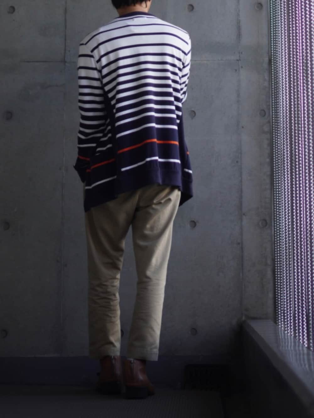 イエロー系のブーツ、ベージュ系のチノパンツ、ホワイト系のTシャツ/カットソーを着用したメンズの春コーディネートの3枚目の写真