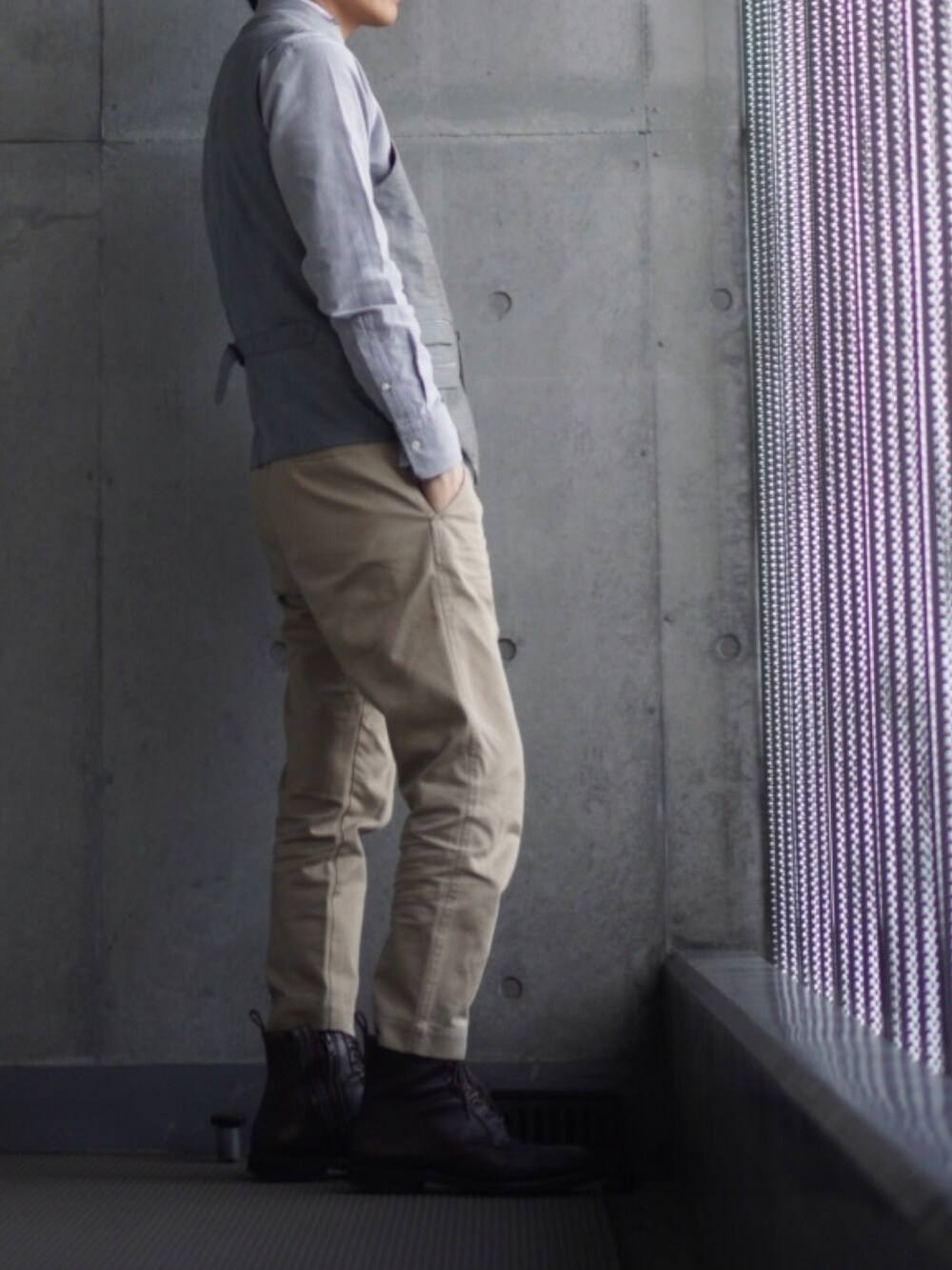 ベージュ系のチノパンツ、ブラウン系のブーツ、グレー系のシャツ/ブラウスを着用したメンズの冬コーディネートの2枚目の写真