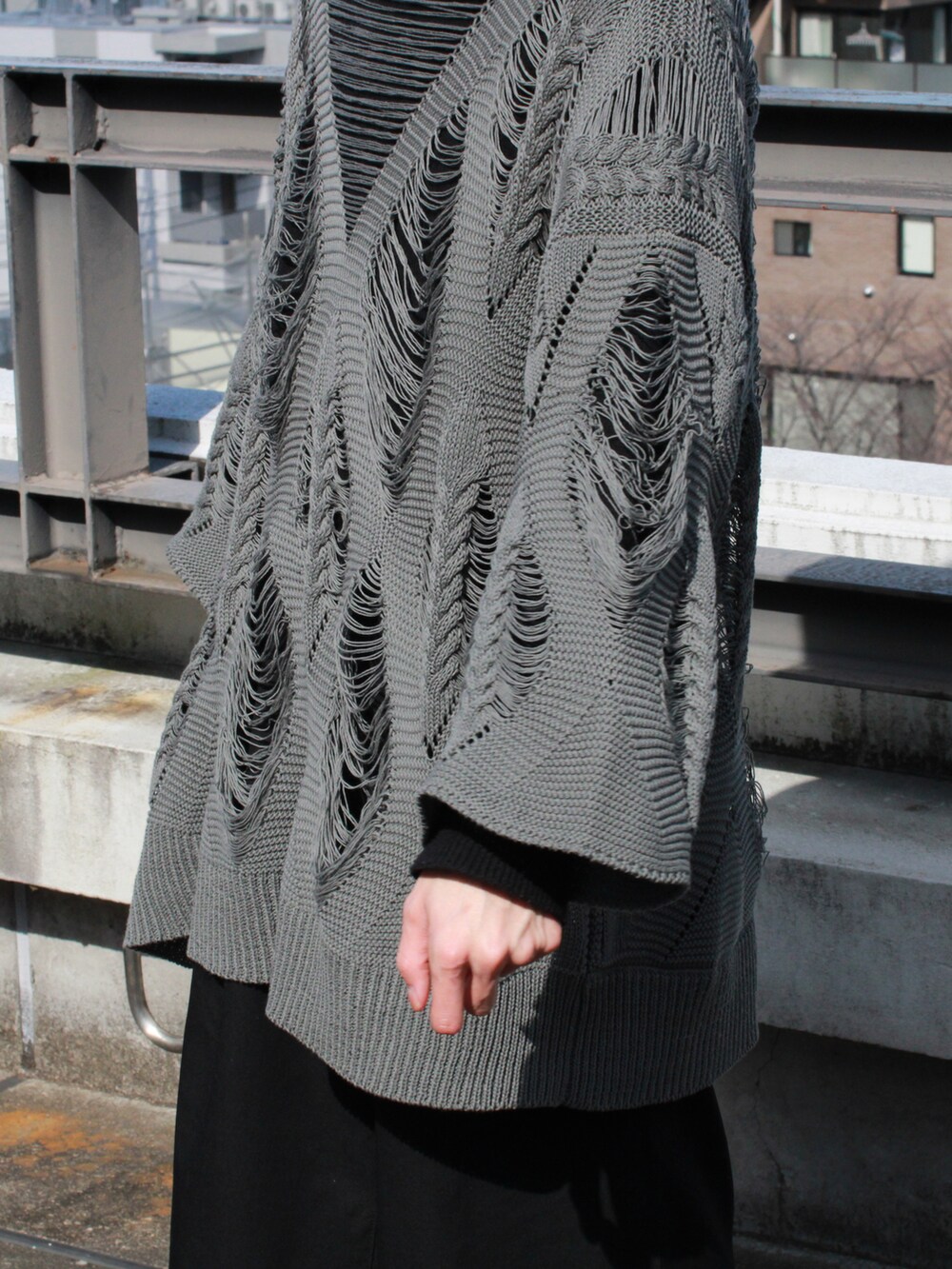 グレー系のニット/セーター、ブラック系のニット/セーター、ブラック系のスラックスを着用したメンズの夏コーディネートの2枚目の写真