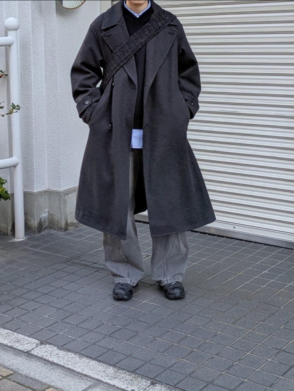 グレー系のその他アウター、ブラック系のショルダーバッグ、グレー系のデニムパンツを着用したメンズの冬コーディネートの3枚目の写真