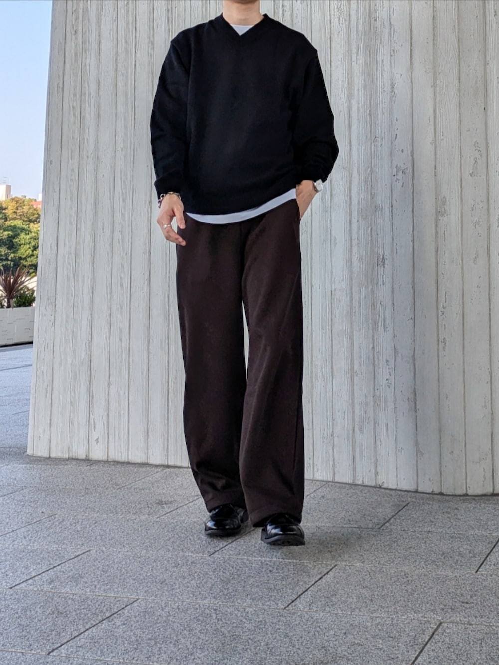 ブラック系のニット/セーター、ブラウン系のスウェットパンツ、ブラック系のドレスシューズを着用したメンズの秋コーディネートの2枚目の写真