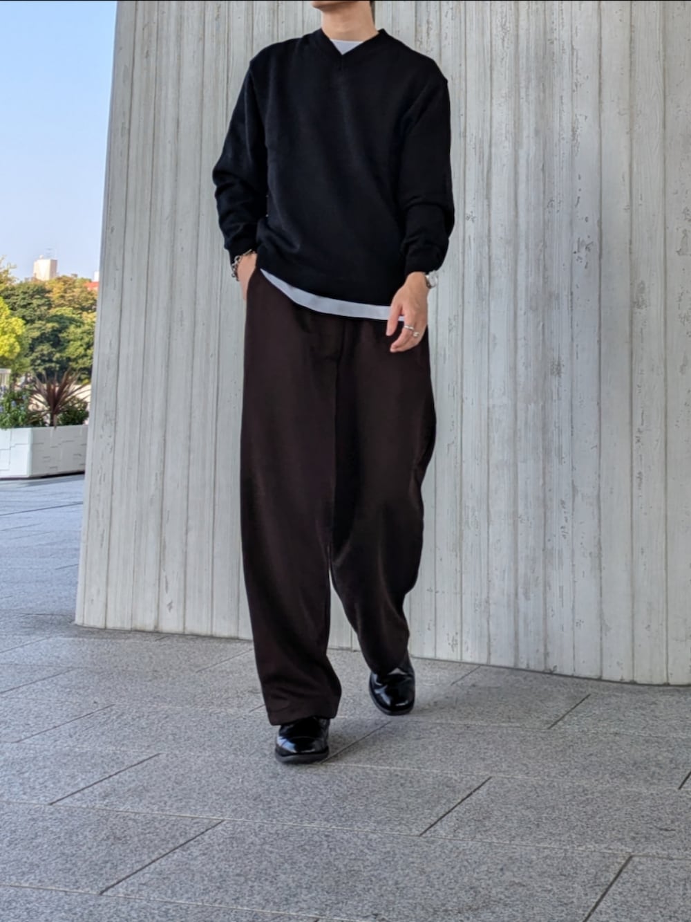 ブラック系のニット/セーター、ブラウン系のスウェットパンツ、ブラック系のドレスシューズを着用したメンズの秋コーディネートの3枚目の写真