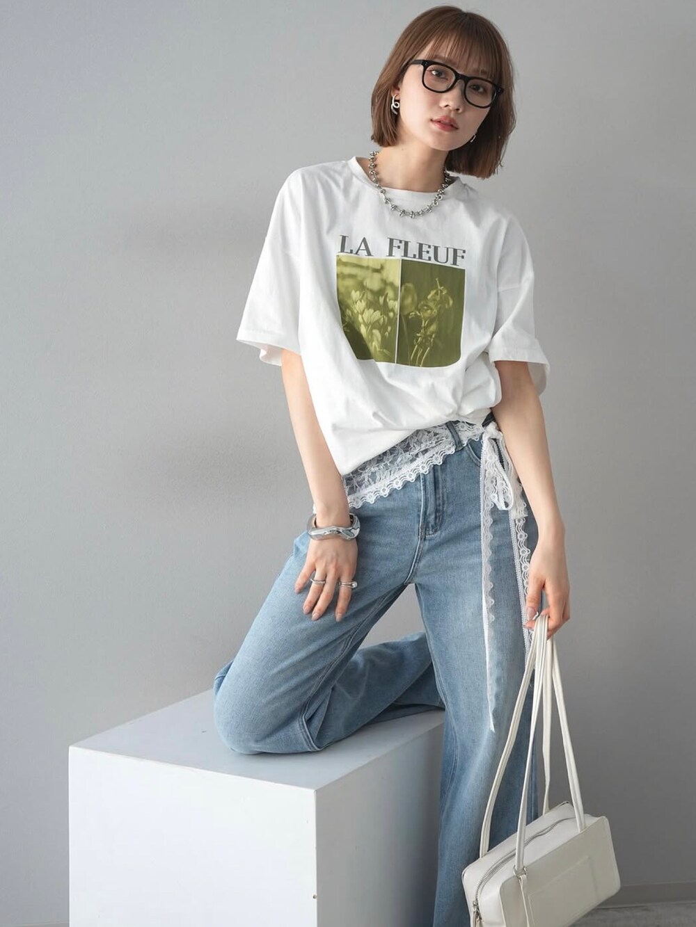 ホワイト系のTシャツ/カットソー、ブルー系のデニムパンツを着用したレディースの春コーディネートの2枚目の写真