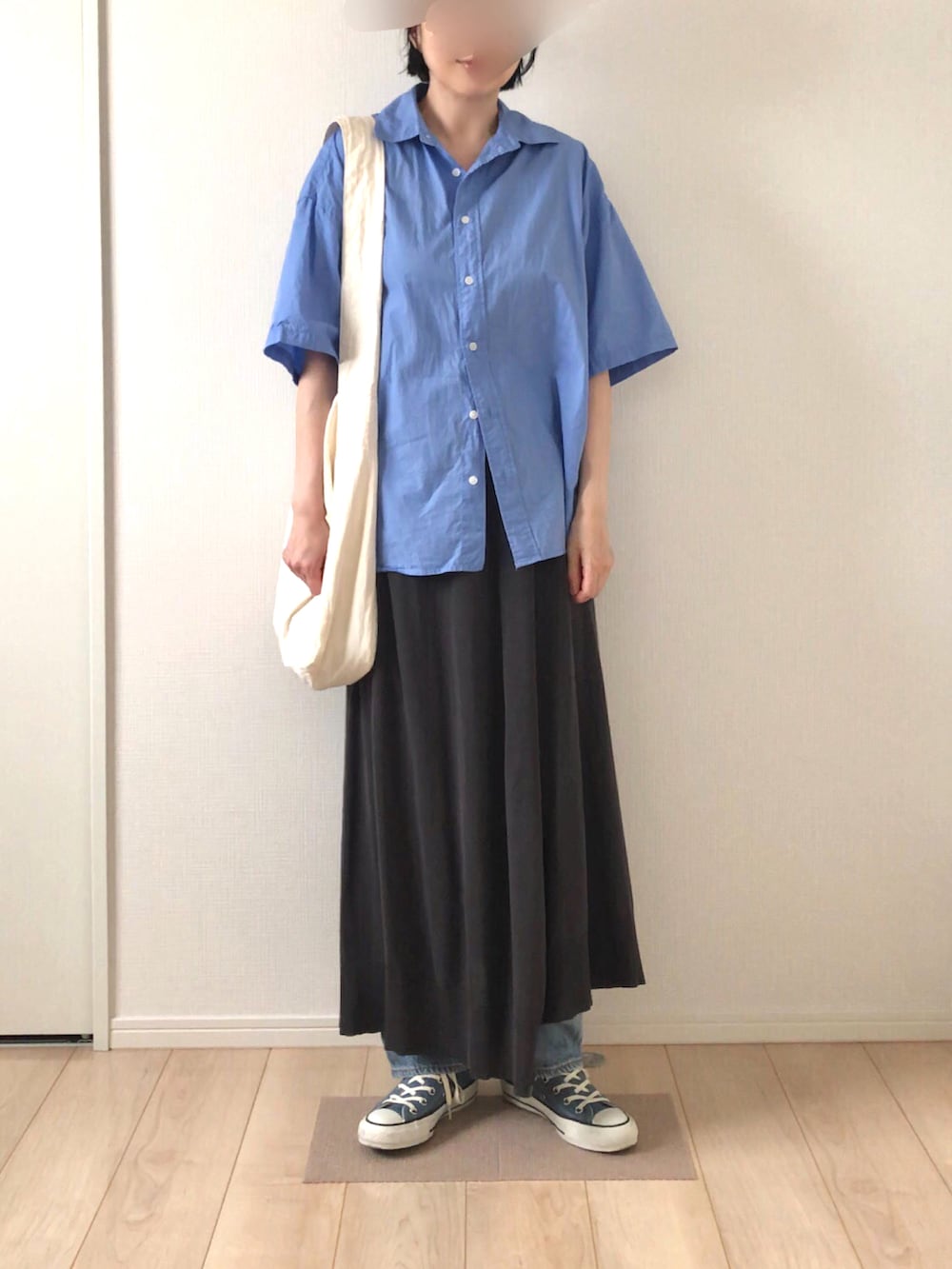 ブルー系のシャツ/ブラウス、ブラック系のスカート、ホワイト系のショルダーバッグを着用したレディースの夏コーディネートの2枚目の写真