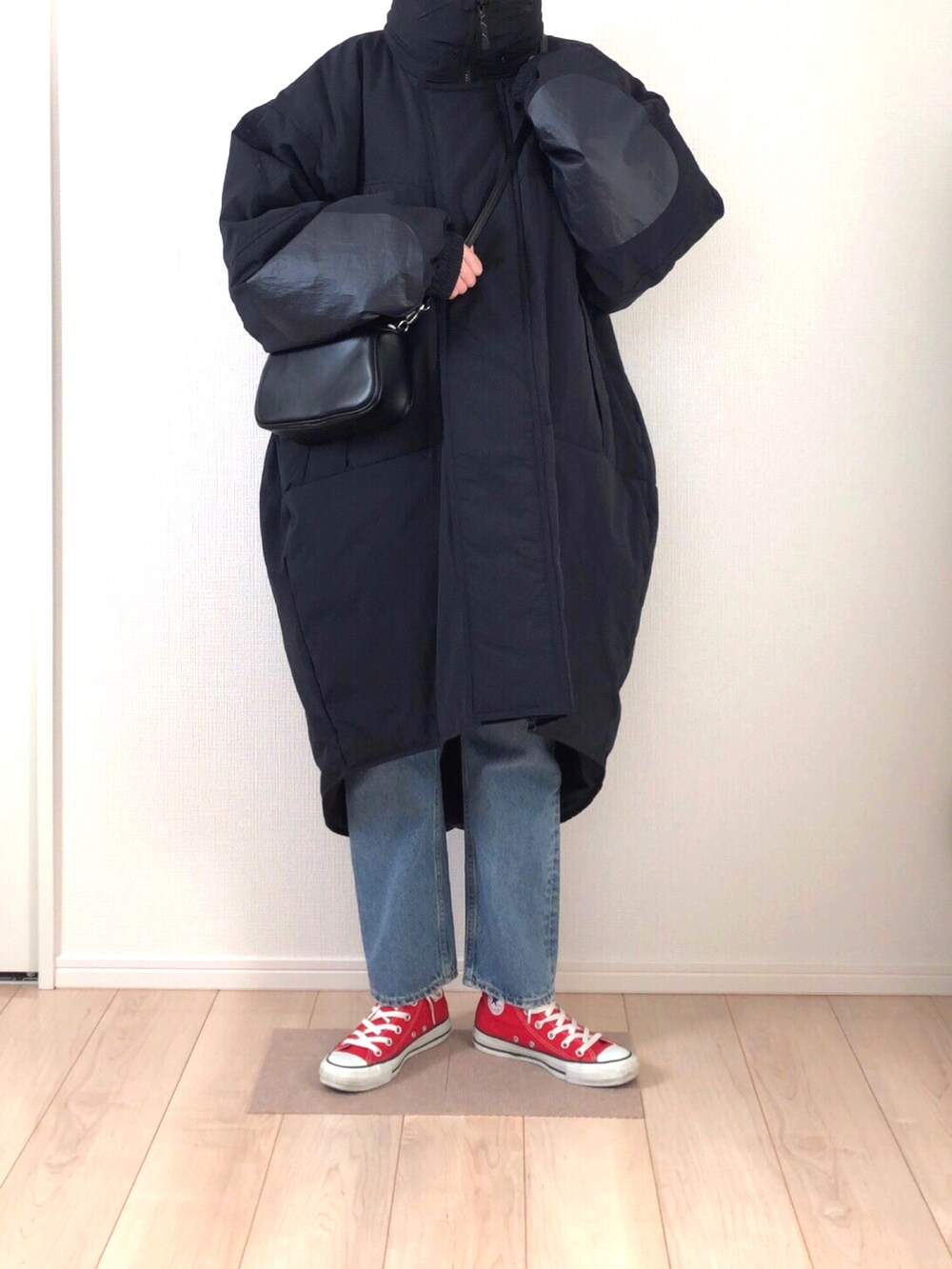 ブラック系のダウンジャケット/コート、ブラック系のハンドバッグ、ブルー系のデニムパンツを着用したレディースの冬コーディネートの3枚目の写真