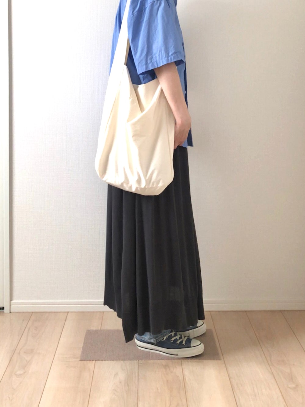 ブルー系のシャツ/ブラウス、ブラック系のスカート、ホワイト系のショルダーバッグを着用したレディースの夏コーディネートの3枚目の写真