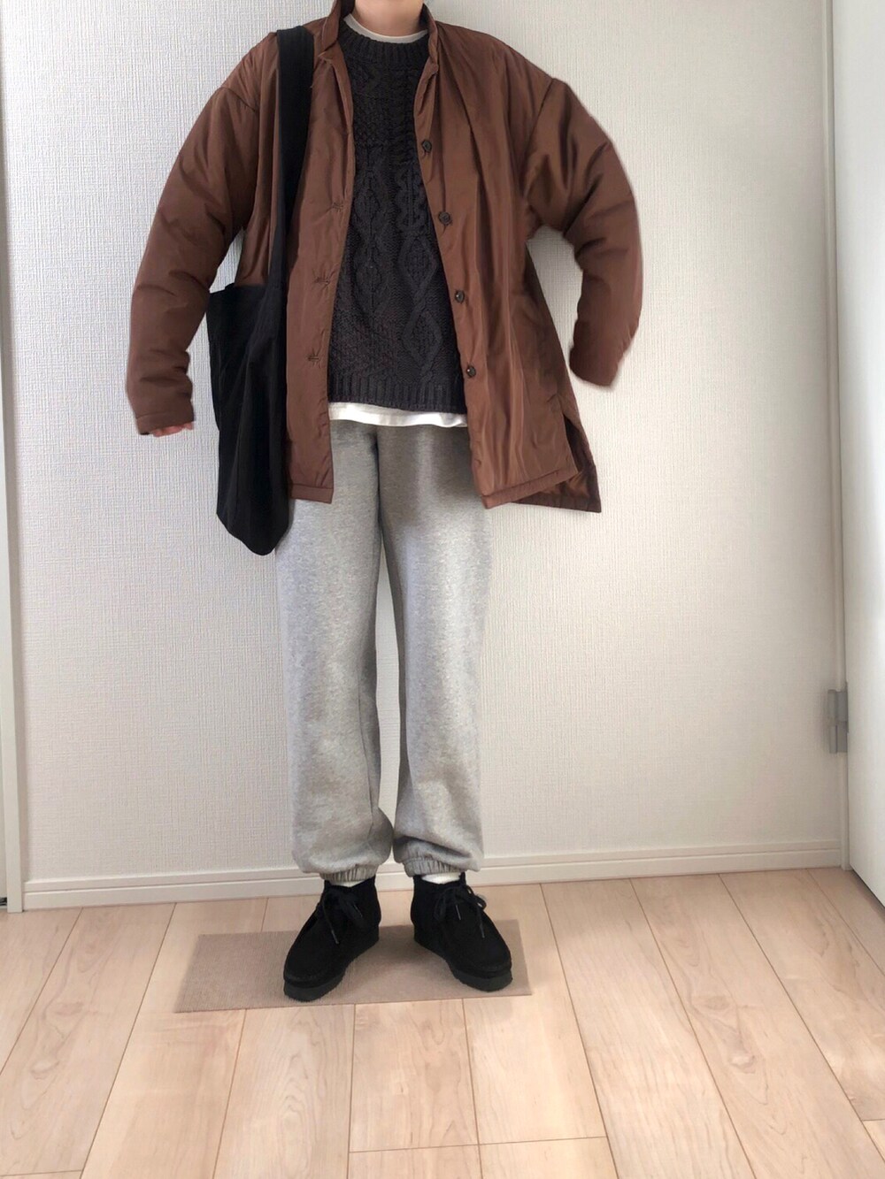 ブラウン系のダウンジャケット/コート、ブラック系のショルダーバッグ、グレー系のスウェットパンツを着用したレディースの冬コーディネートの3枚目の写真