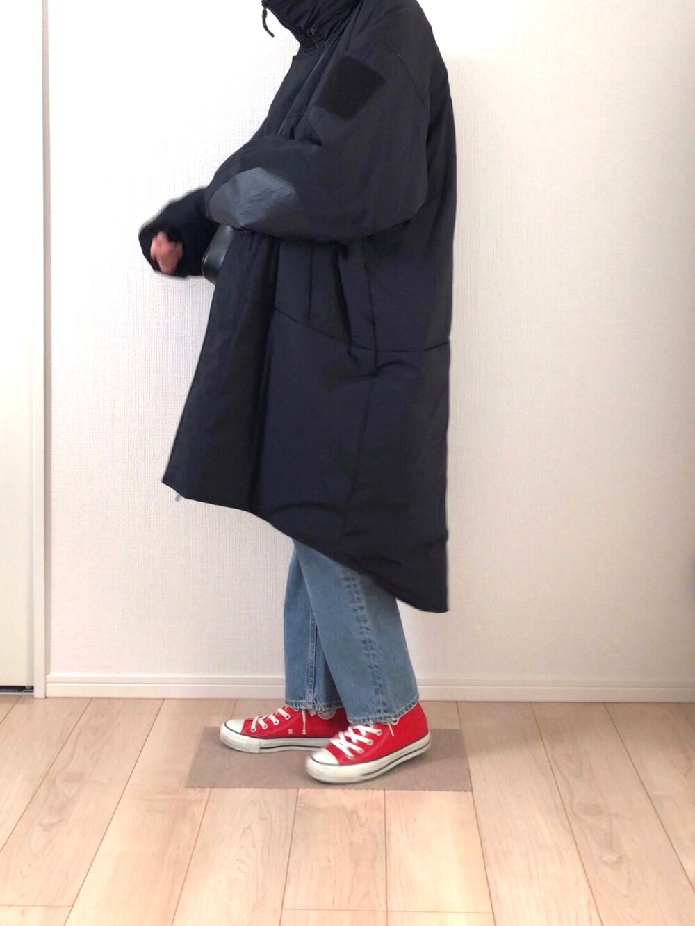 ブラック系のダウンジャケット/コート、ブラック系のハンドバッグ、ブルー系のデニムパンツを着用したレディースの冬コーディネートの2枚目の写真