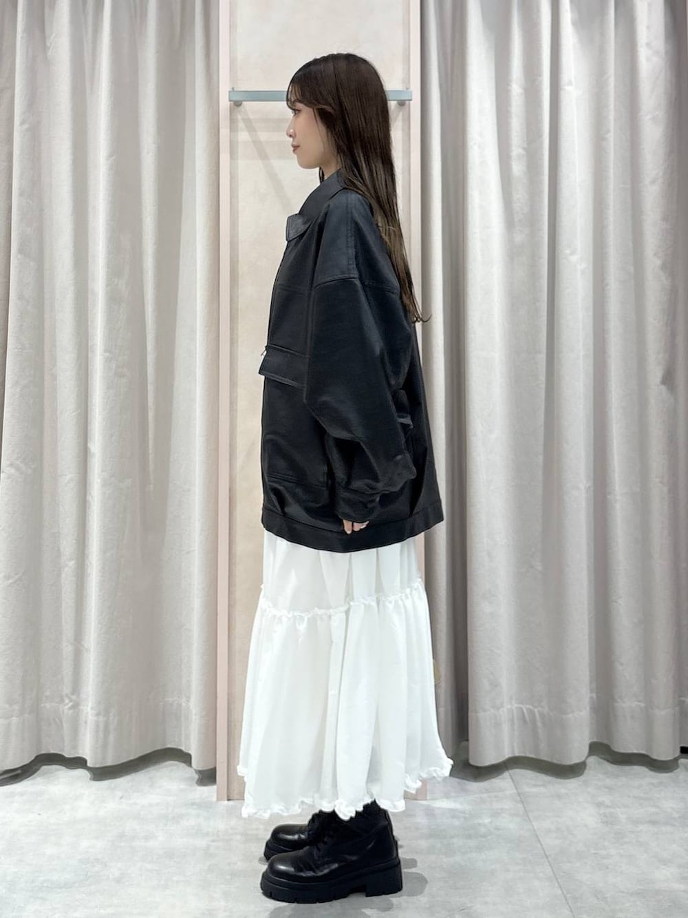 ブラック系のキャミソール、ブラック系のブルゾン、ベージュ系のボストンバッグを着用したレディースの秋コーディネートの2枚目の写真