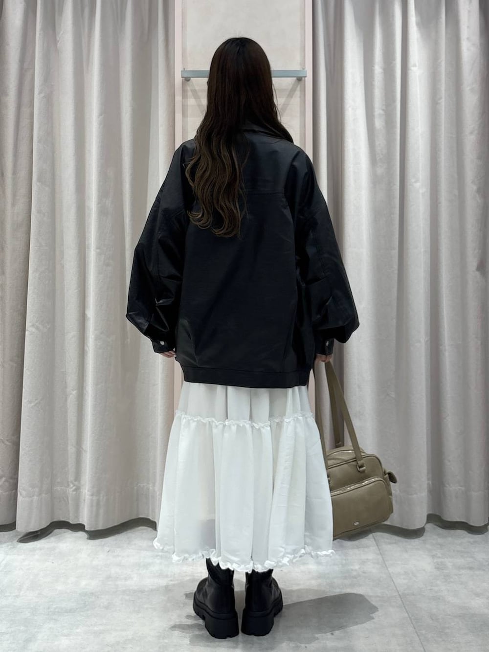 ブラック系のキャミソール、ブラック系のブルゾン、ベージュ系のボストンバッグを着用したレディースの秋コーディネートの3枚目の写真