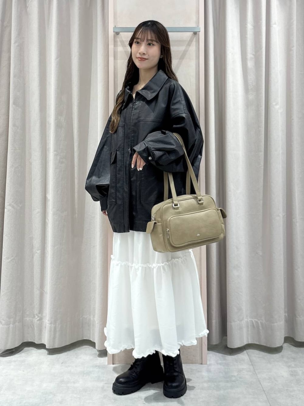 ブラック系のキャミソール、ブラック系のブルゾン、ベージュ系のボストンバッグを着用したレディースの秋コーディネートの6枚目の写真