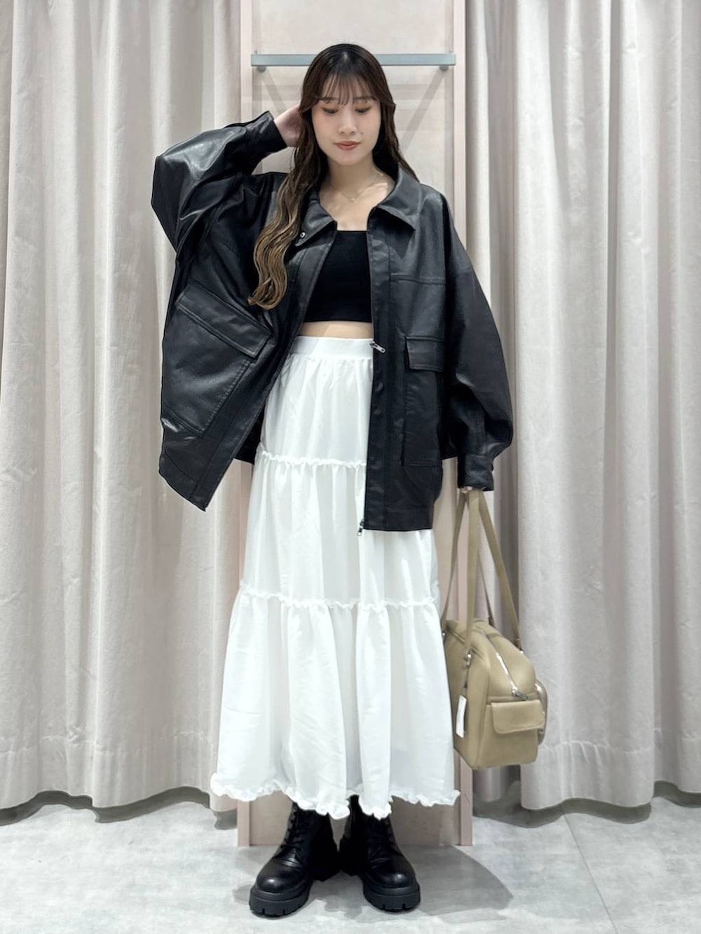 ブラック系のキャミソール、ブラック系のブルゾン、ベージュ系のボストンバッグを着用したレディースの秋コーディネートの7枚目の写真