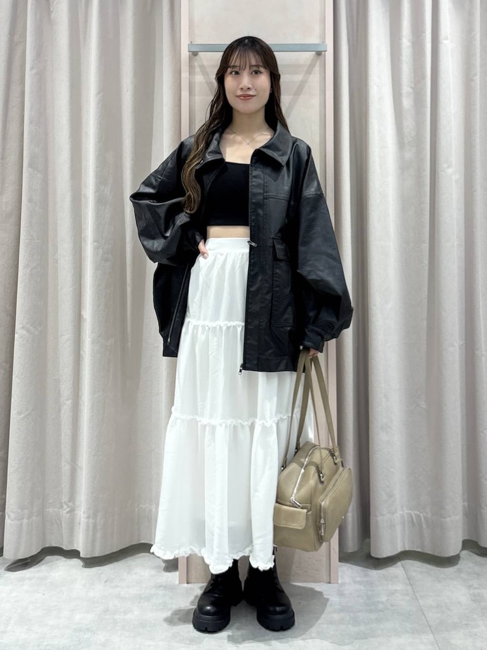 ブラック系のキャミソール、ブラック系のブルゾン、ベージュ系のボストンバッグを着用したレディースの秋コーディネートの8枚目の写真