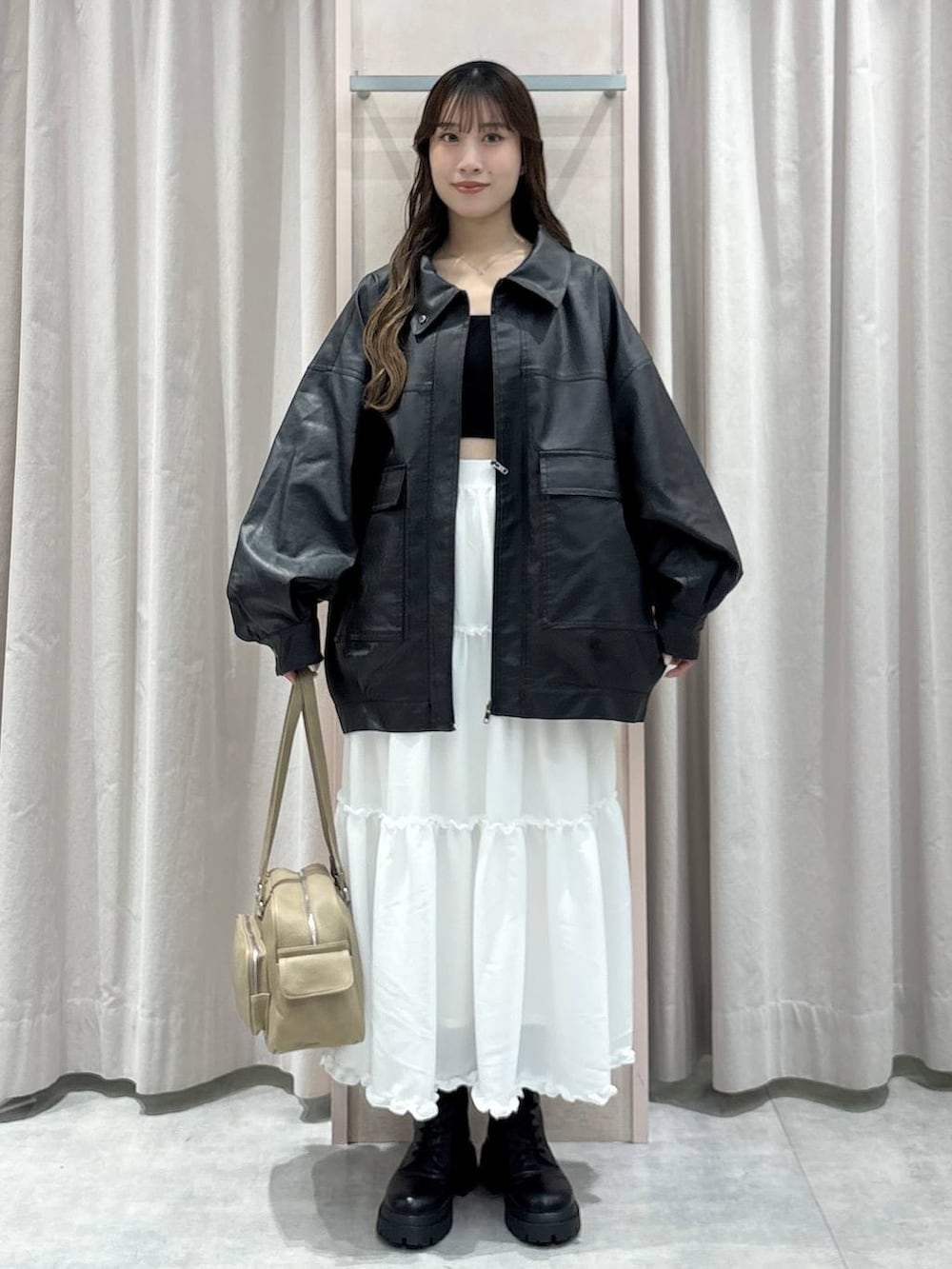 ブラック系のキャミソール、ブラック系のブルゾン、ベージュ系のボストンバッグを着用したレディースの秋コーディネートの5枚目の写真