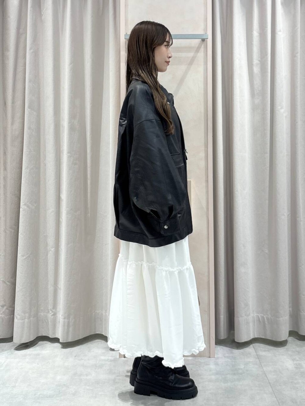 ブラック系のキャミソール、ブラック系のブルゾン、ベージュ系のボストンバッグを着用したレディースの秋コーディネートの4枚目の写真