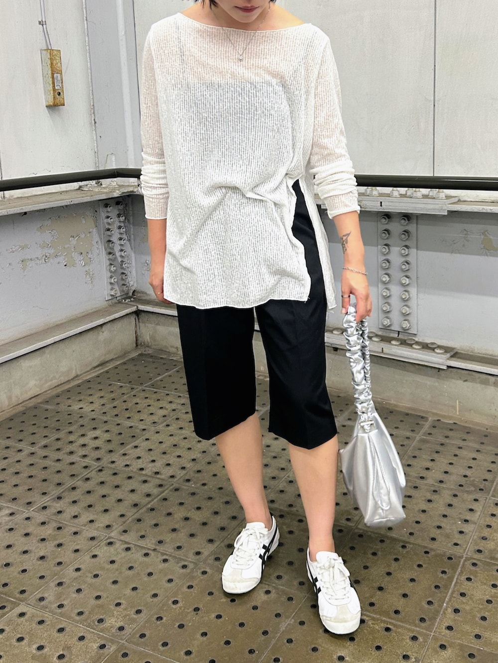 ホワイト系のスニーカー、シルバー系のショルダーバッグ、ホワイト系のTシャツ/カットソーを着用したレディースの秋コーディネートの2枚目の写真