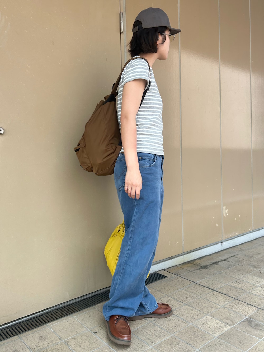 グレー系のTシャツ/カットソー、ブルー系のデニムパンツ、ブラウン系のモカシン/デッキシューズを着用したレディースの秋コーディネートの2枚目の写真