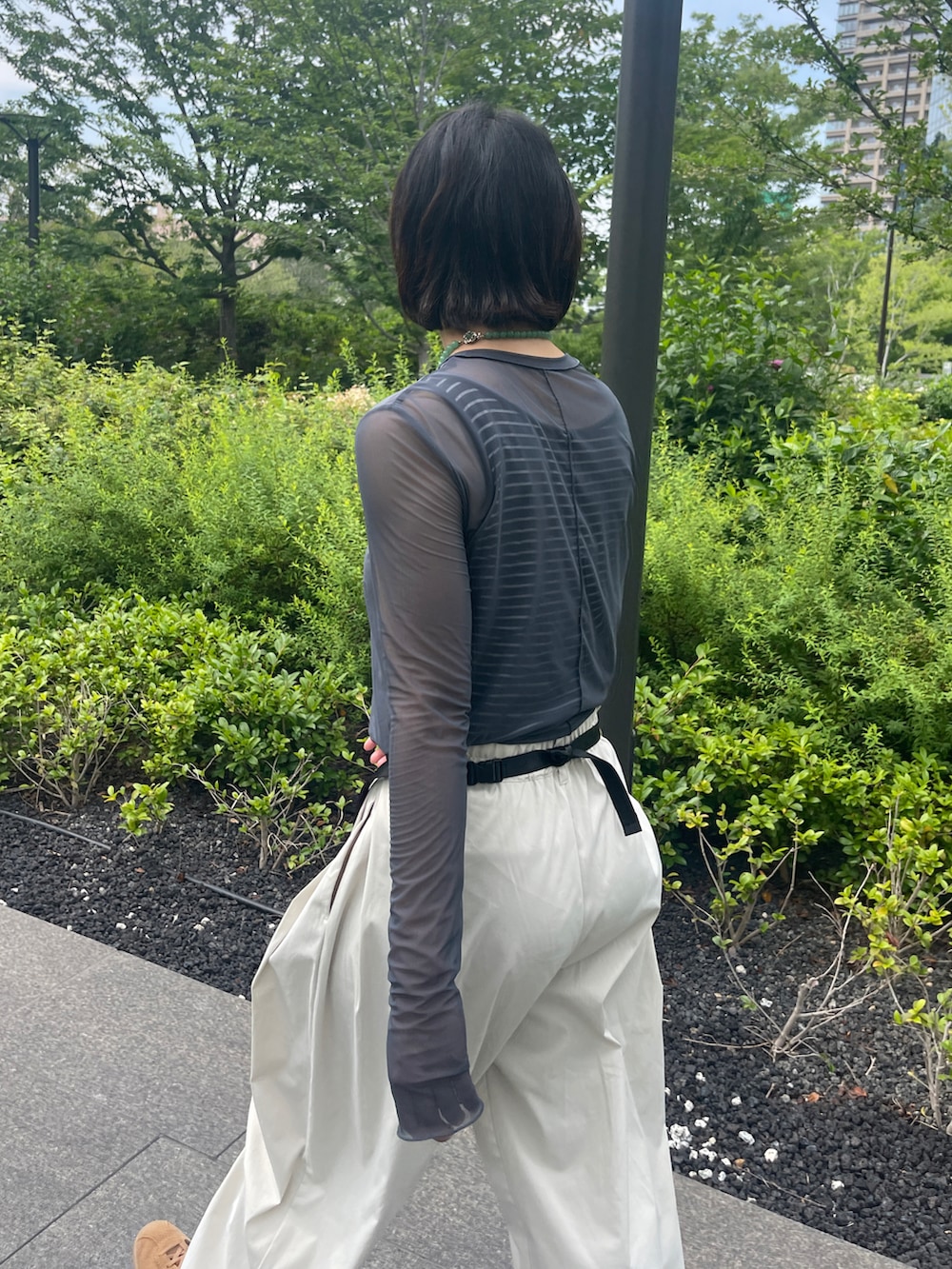 ホワイト系のその他パンツ、ベージュ系のボディバッグ/ウエストポーチ、ブラウン系のスニーカーを着用したレディースの夏コーディネートの2枚目の写真
