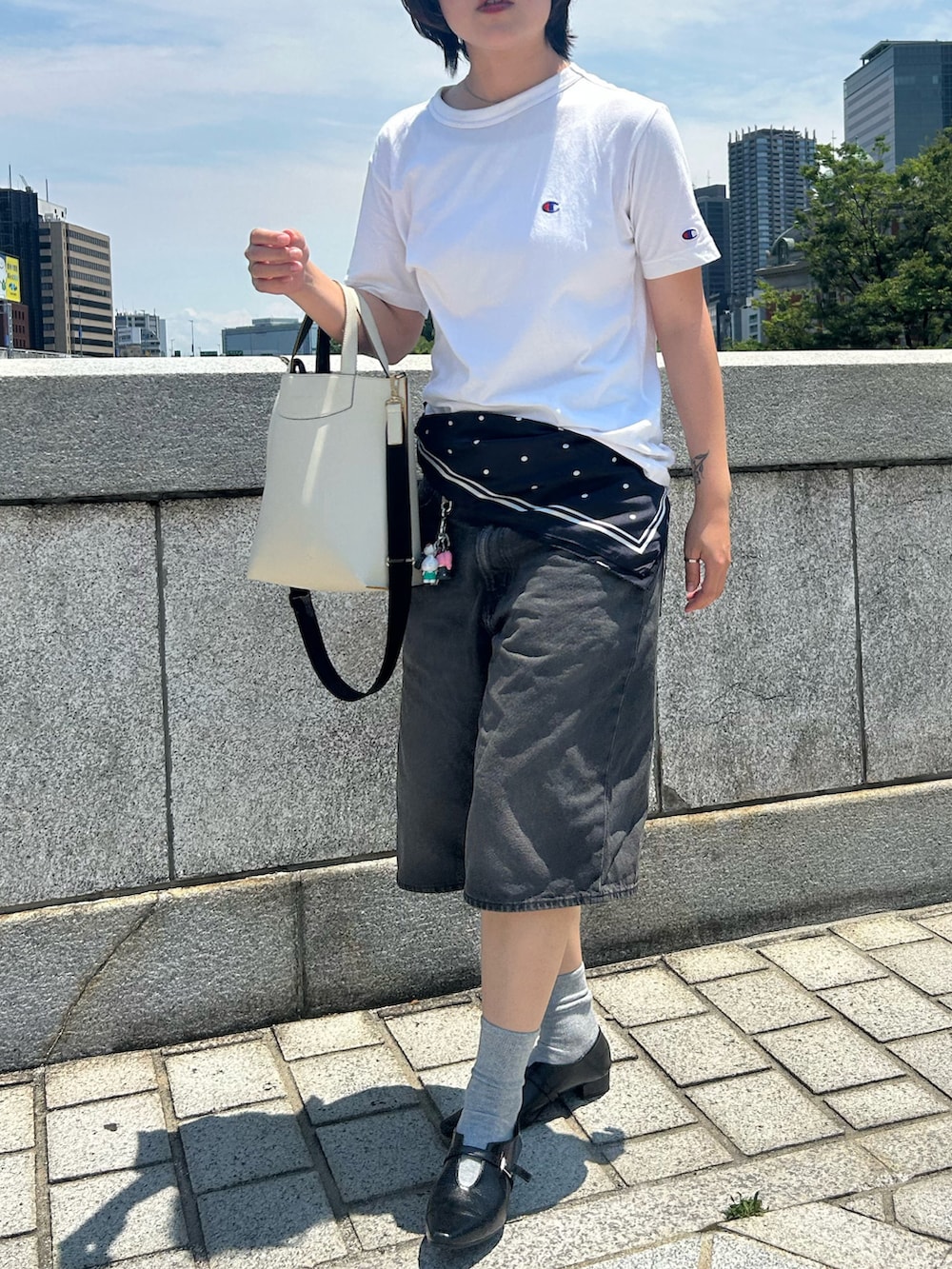 ホワイト系のTシャツ/カットソー、ブラック系のパンプス、グレー系のデニムパンツを着用したレディースの夏コーディネートの2枚目の写真