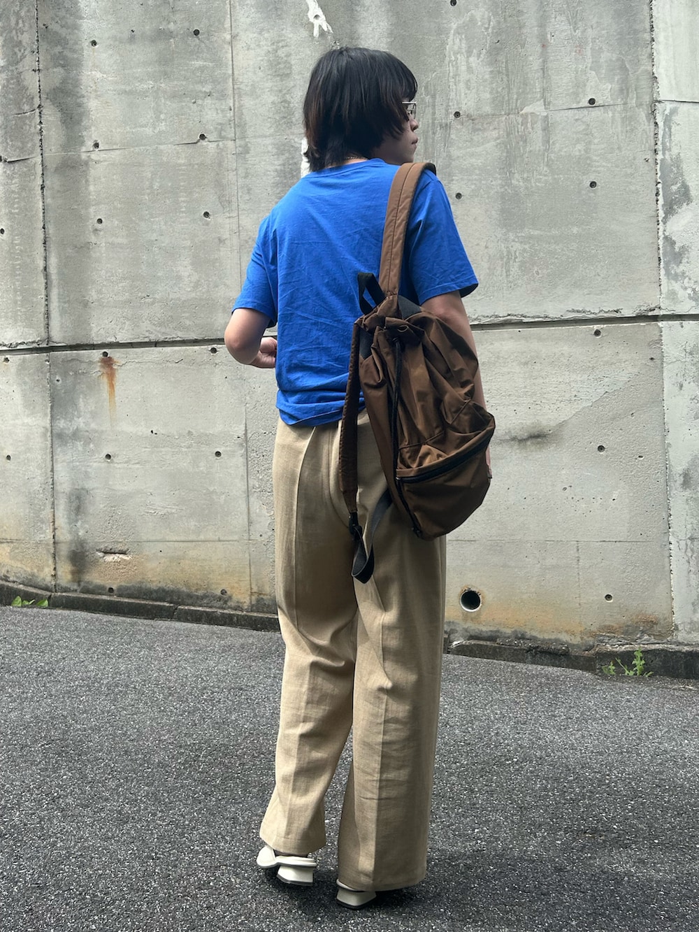 ホワイト系のサンダル、ブルー系のTシャツ/カットソー、ベージュ系のスラックスを着用したレディースの夏コーディネートの2枚目の写真