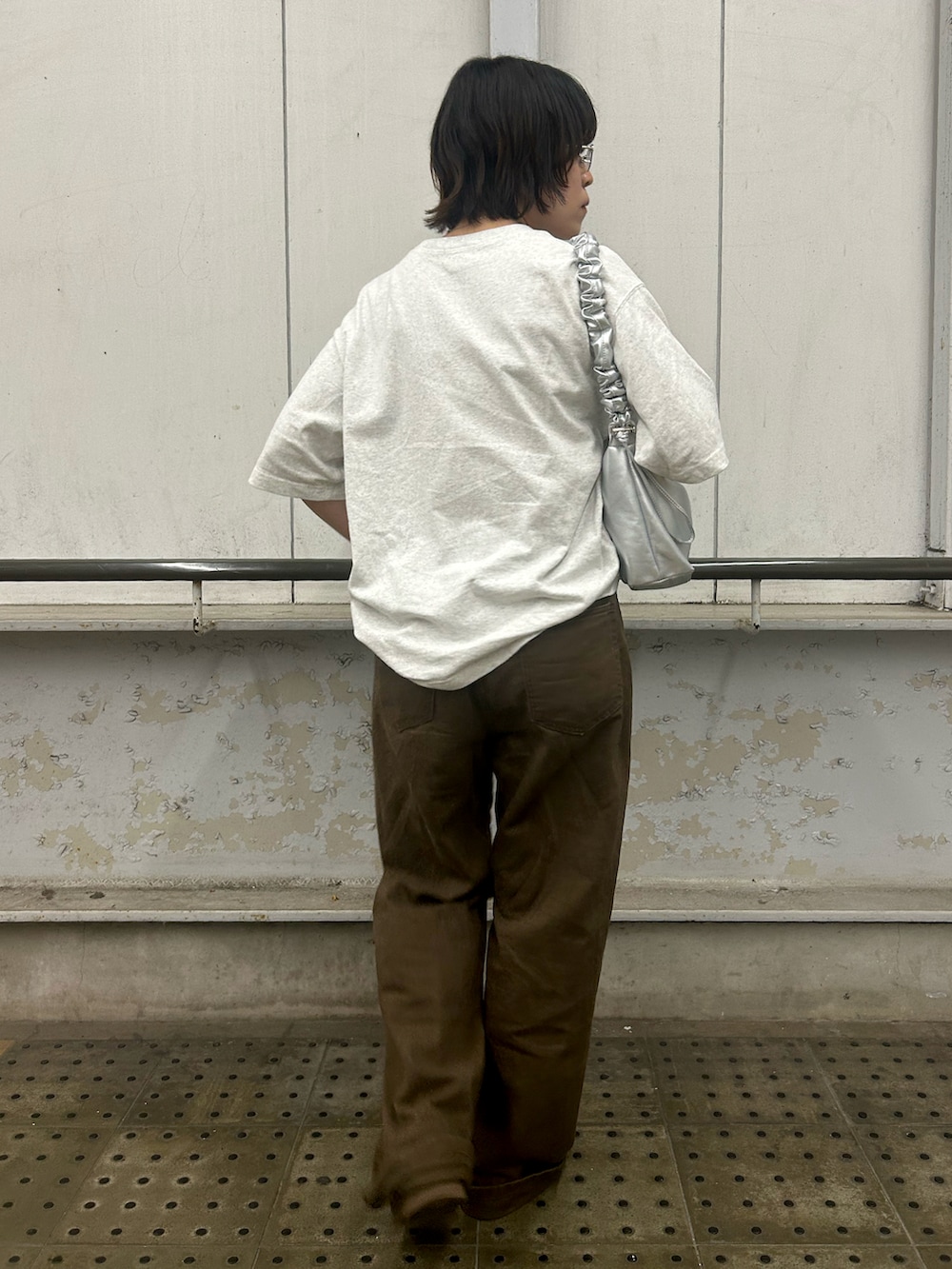 ホワイト系のTシャツ/カットソー、シルバー系のショルダーバッグ、ブラウン系のデニムパンツを着用したレディースの夏コーディネートの3枚目の写真