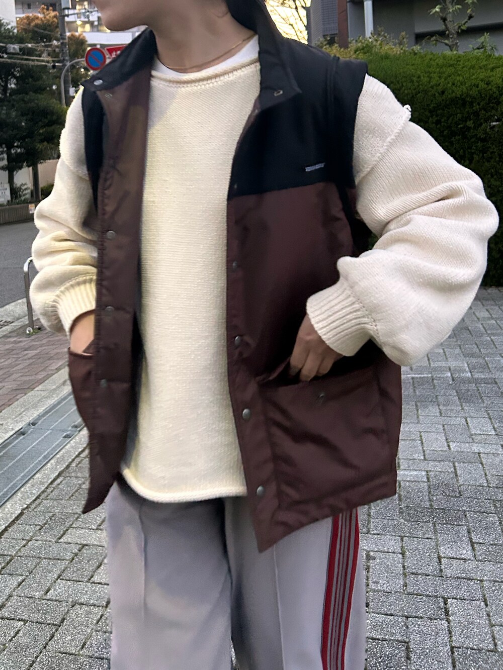 グレー系のその他パンツ、ホワイト系のニット/セーター、ベージュ系のスニーカーを着用したレディースの春コーディネートの3枚目の写真