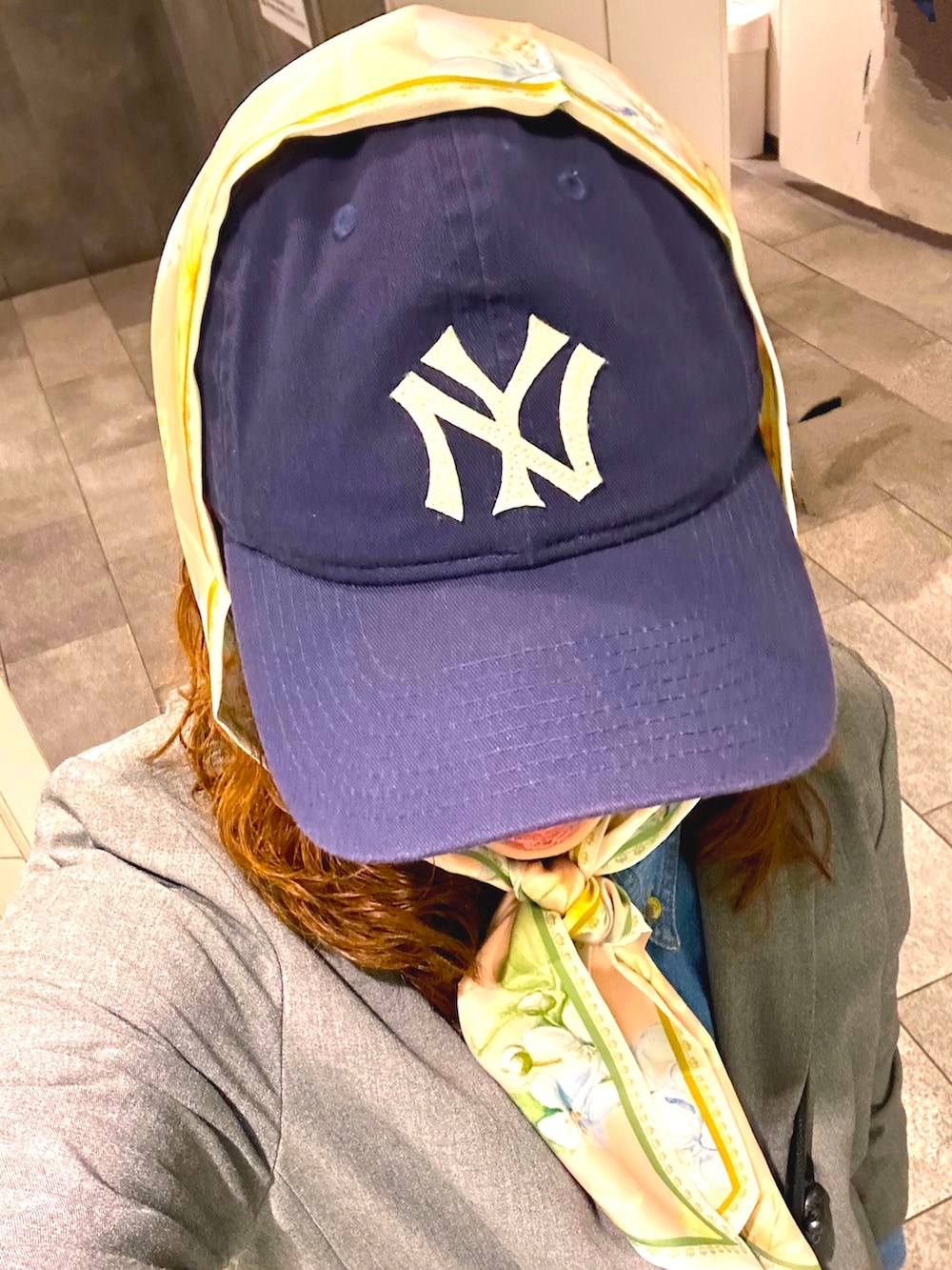 グレー系のテーラードジャケット、グレー系のスラックス、ブラウン系のスカートを着用したレディースの春コーディネートの2枚目の写真