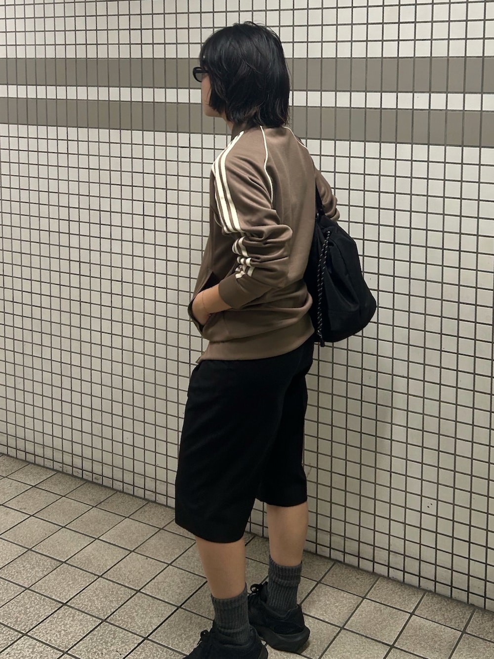 ブラック系のスニーカー、ベージュ系のジャージ、ブラック系のパンツを着用したレディースの秋コーディネートの2枚目の写真