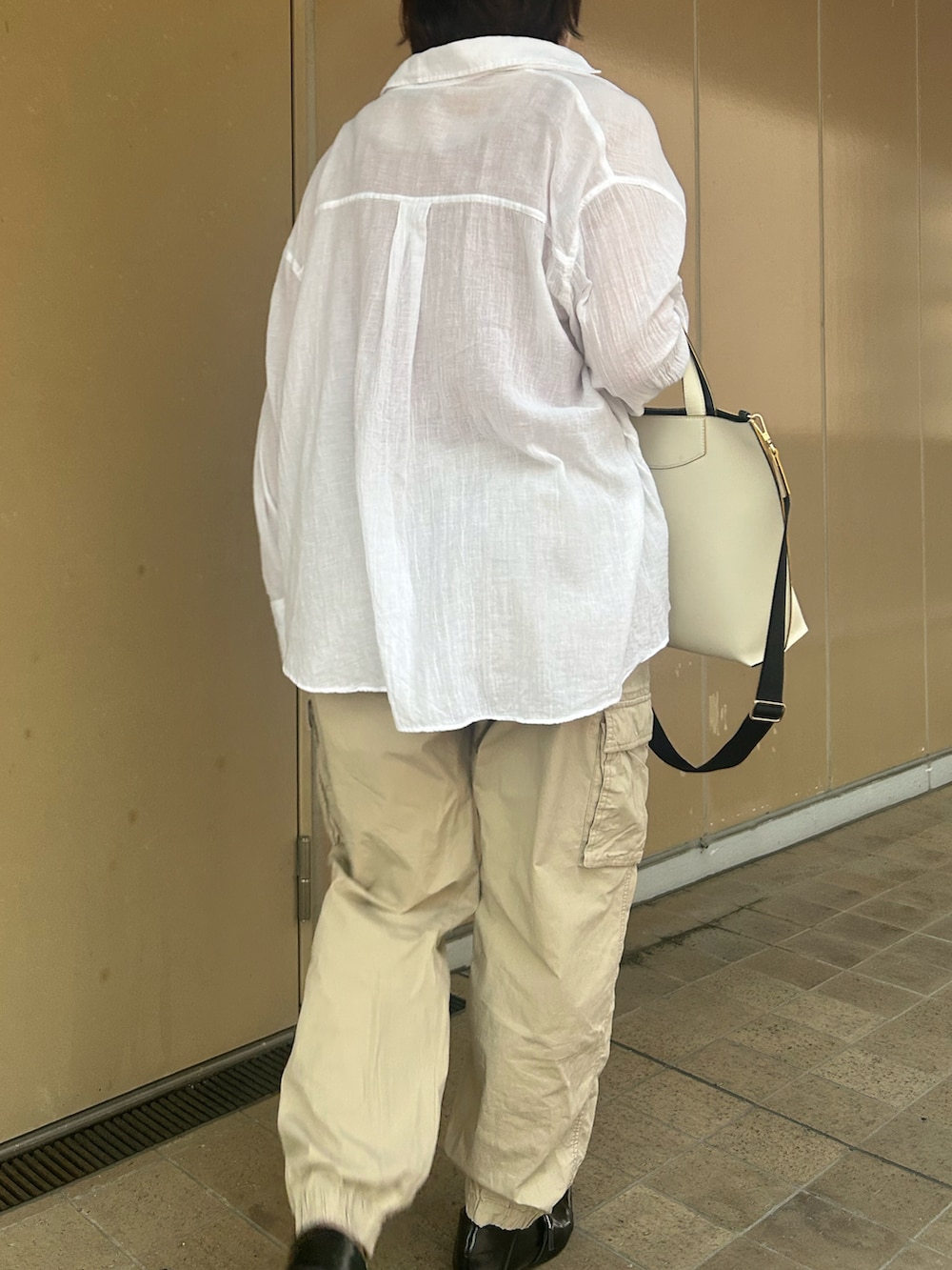 ブラック系のパンプス、ベージュ系のカーゴパンツ、ホワイト系のシャツ/ブラウスを着用したレディースの夏コーディネートの2枚目の写真