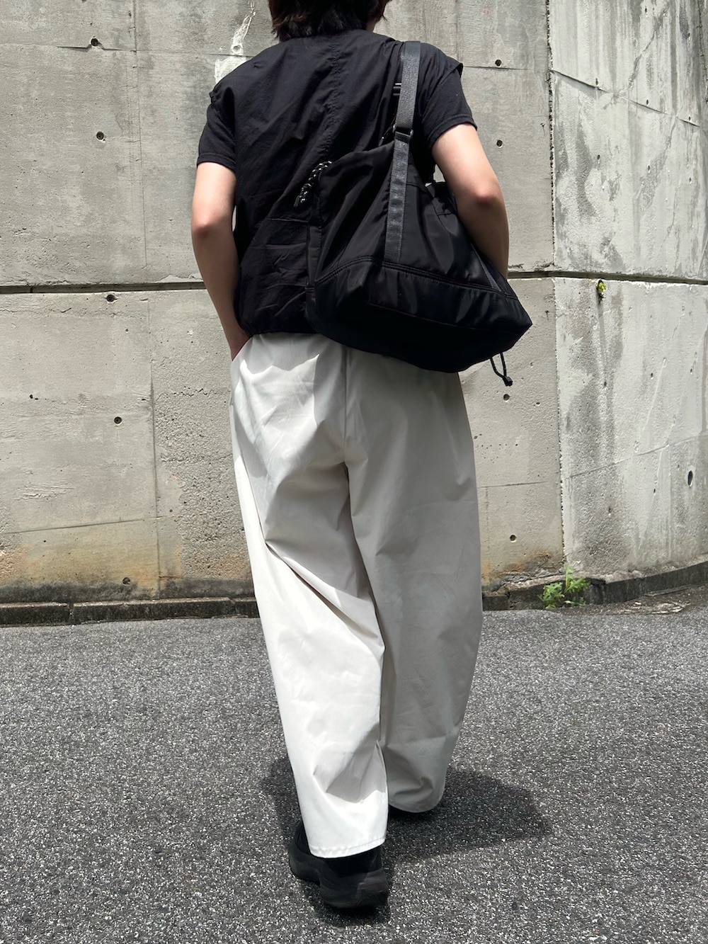 ホワイト系のその他パンツ、ブラック系のベスト、ブラック系のスニーカーを着用したレディースの夏コーディネートの3枚目の写真