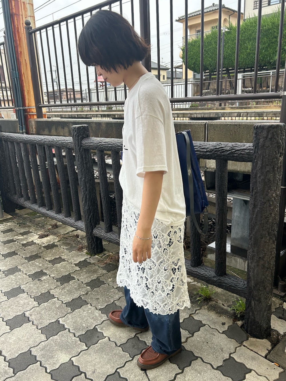 ホワイト系のスカート、ホワイト系のTシャツ/カットソー、ブルー系のデニムパンツを着用したレディースの夏コーディネートの2枚目の写真