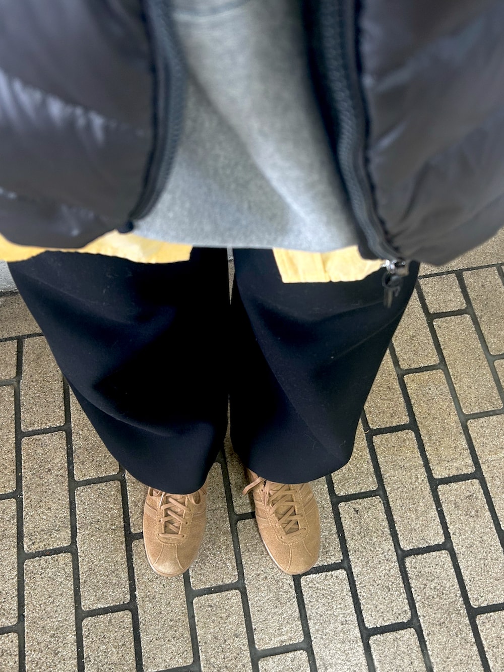 イエロー系のシャツ/ブラウス、グレー系のパーカー、グレー系のダウンベストを着用したレディースの春コーディネートの2枚目の写真