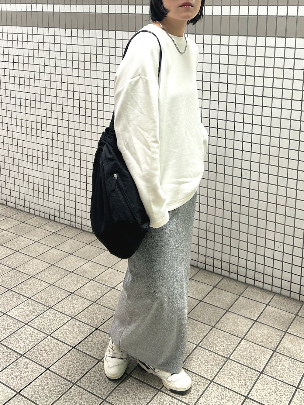 ホワイト系のTシャツ/カットソー、シルバー系のスカート、ホワイト系のスニーカーを着用したレディースの秋コーディネートの2枚目の写真